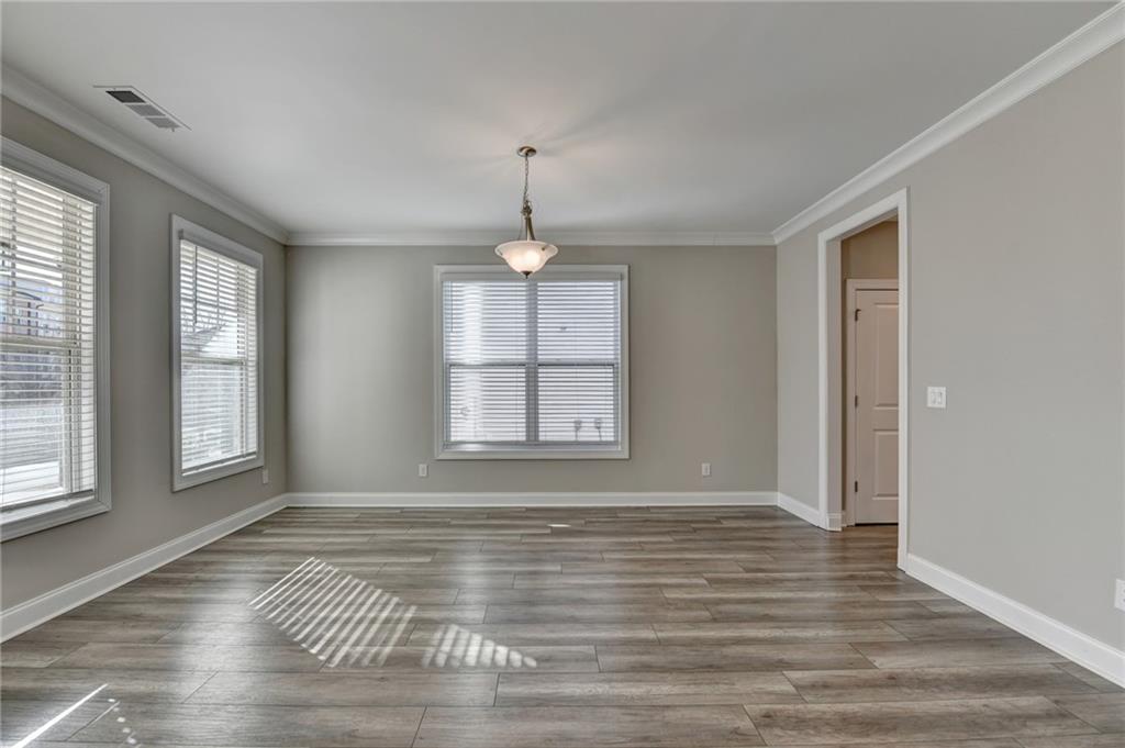 3445 Benedict Place Suwanee, GA 30024 - Photo 5 of 59 an empty room with wooden floor and windows