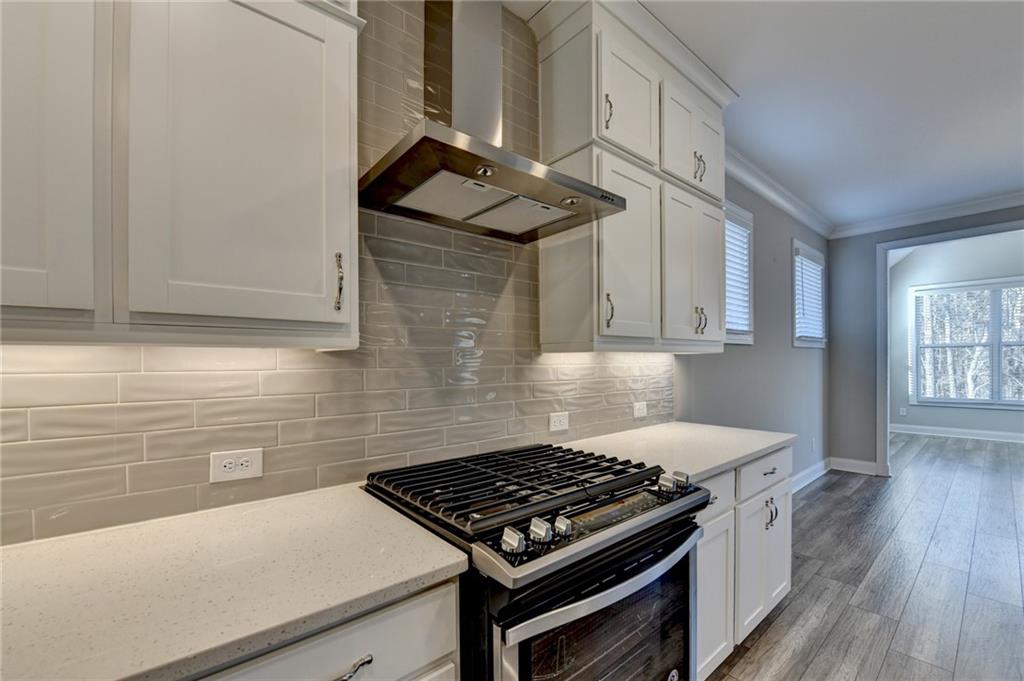 3445 Benedict Place Suwanee, GA 30024 - Photo 10 of 59 a kitchen with wooden cabinets and a stove top oven