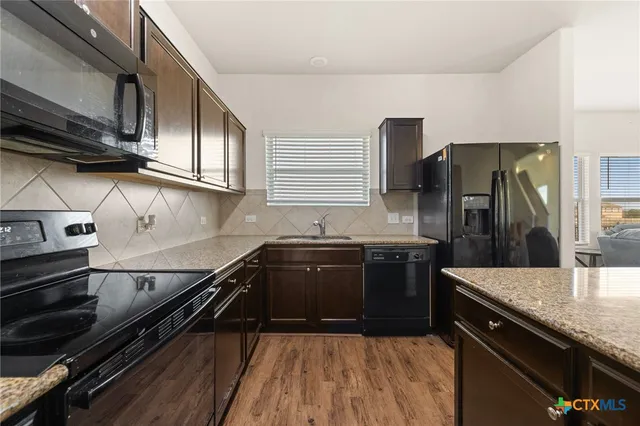 a kitchen with a sink appliances and cabinets