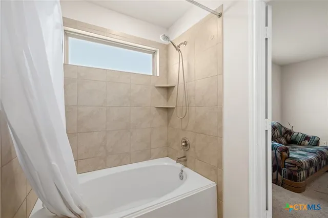 a bathroom with a tub and a shower