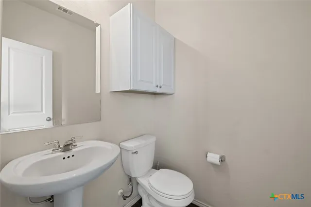 a bathroom with a sink a toilet and mirror
