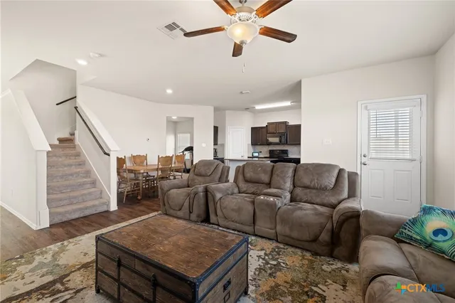 a living room with furniture kitchen view and a window