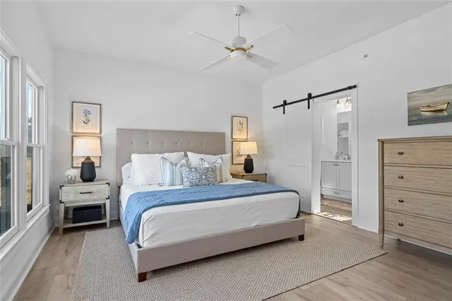 a bedroom with a bed and large windows