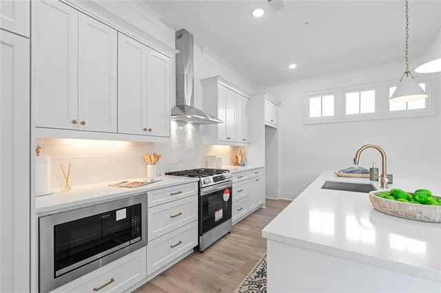 a kitchen with a sink stove and wooden floor
