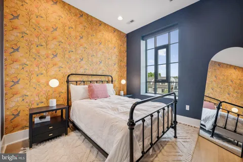 a bedroom with a bed window and a potted plant on table
