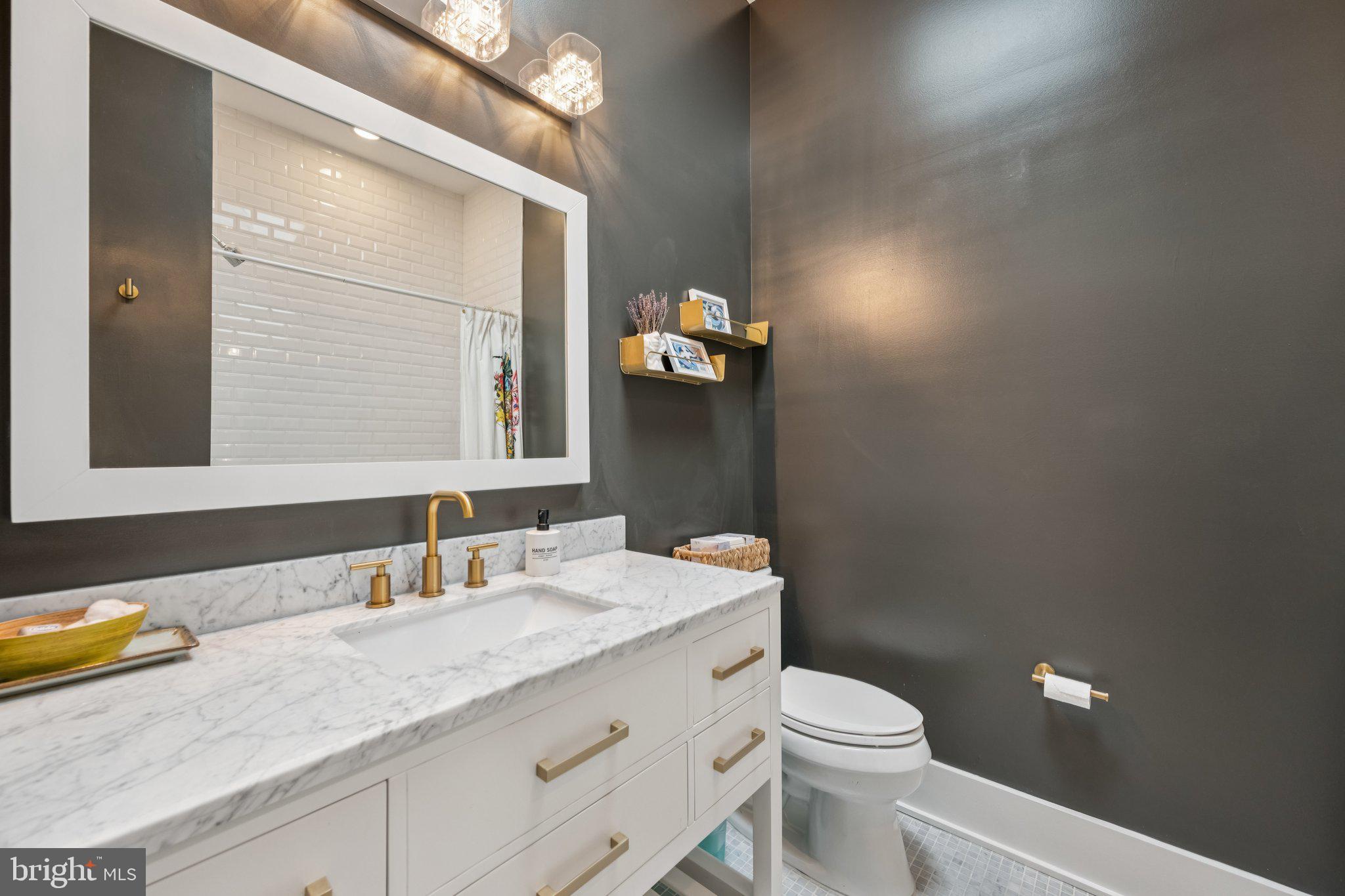 1316 Shepherd Street Northwest, Unit 4 Washington, DC 20011 - Photo 17 of 25 a bathroom with a granite countertop toilet sink and mirror