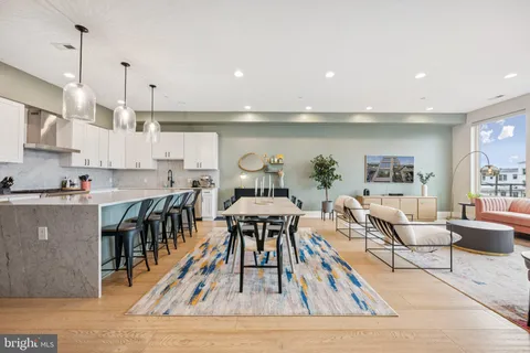 a living room with furniture a wooden floor and a kitchen view