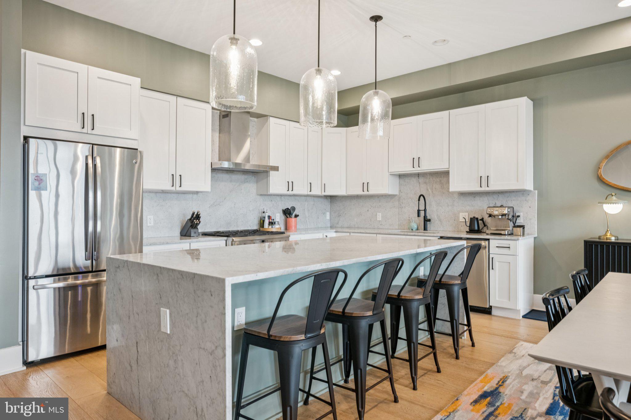 1316 Shepherd Street Northwest, Unit 4 Washington, DC 20011 - Photo 7 of 25 a kitchen with stainless steel appliances granite countertop a sink a stove a refrigerator cabinets and chairs