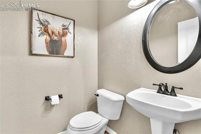 a bathroom with a toilet a sink and mirror