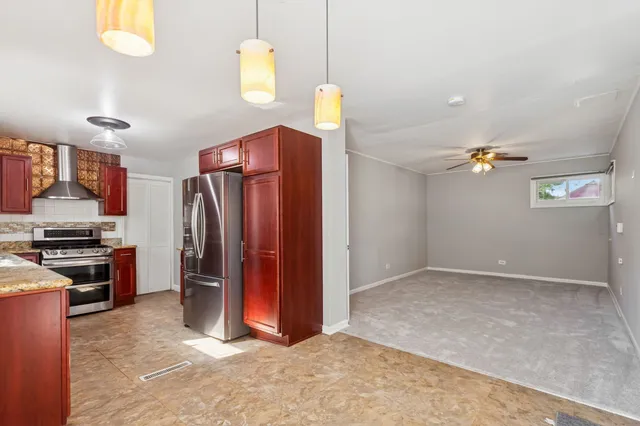 a view of a kitchen with fridge and wooden floor