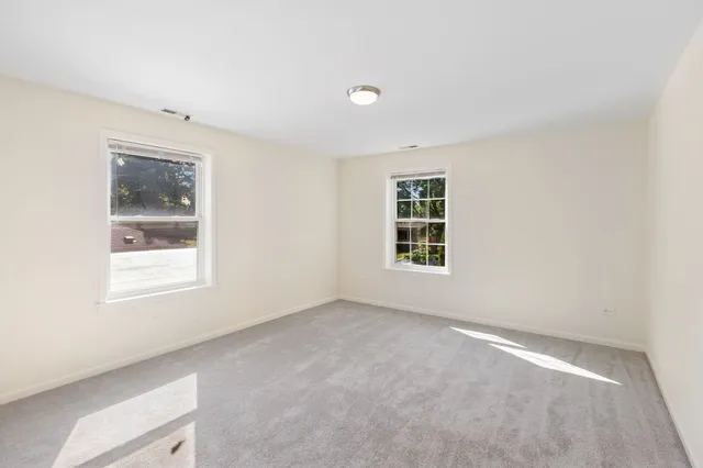 an empty room with windows and closet
