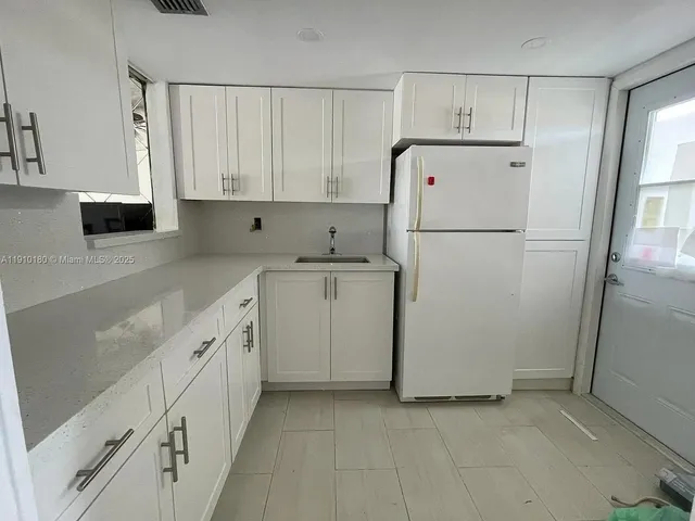 a kitchen with cabinets a refrigerator and a sink