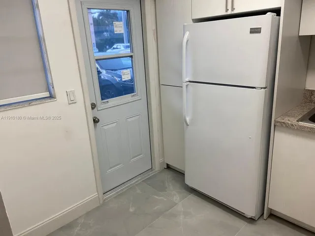 a white refrigerator freezer and a stove sitting inside of a kitchen