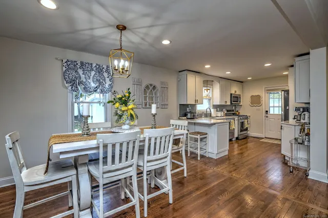 a view of a dining room with furniture a chandelier and wooden floor