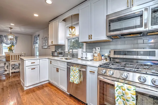 a kitchen with stainless steel appliances granite countertop a stove and cabinets