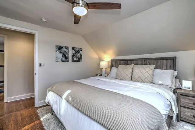 a bedroom with a large bed and a painting on the wall