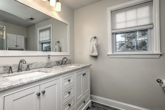 a bathroom with a granite countertop sink a mirror and a window