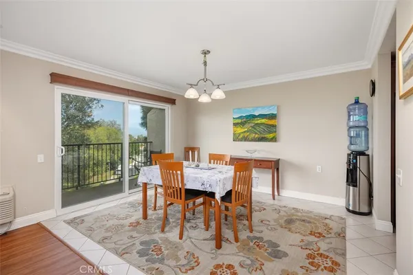 a dining room with furniture a rug a potted plant and a chandelier