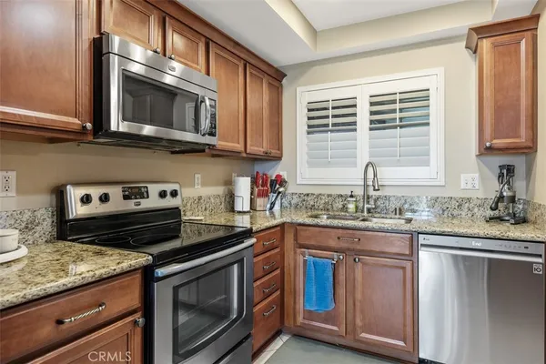 a kitchen with stainless steel appliances granite countertop a sink stove and microwave