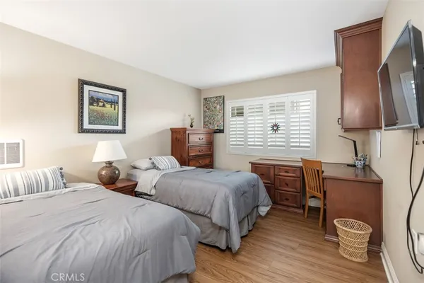 a bedroom with two beds and painting on the wall