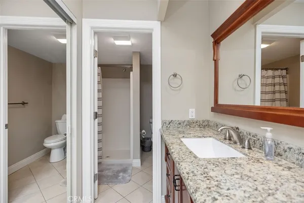 a bathroom with a granite countertop sink and a mirror