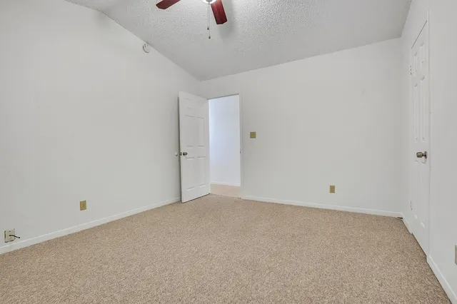 an empty room with a ceiling fan and window