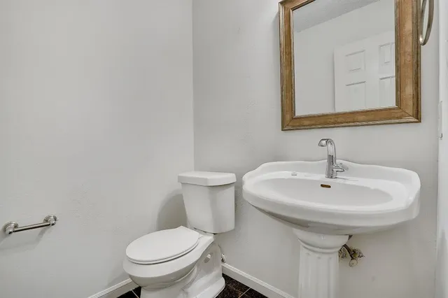 a bathroom with a sink a toilet and mirror