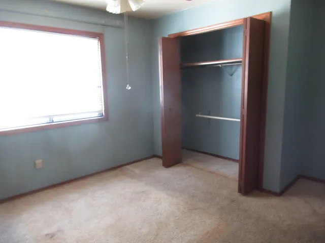an empty room with windows and closet