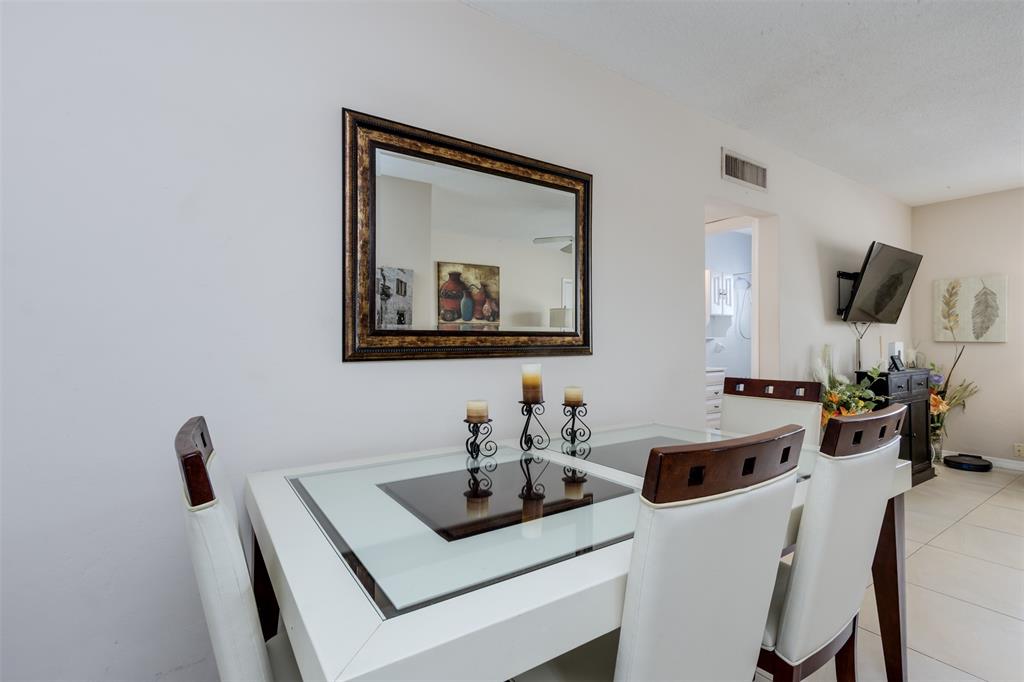 350 South Cypress Road, Unit 522 Pompano Beach, FL 33060 - Photo 23 of 27 a dining room with furniture and a mirror