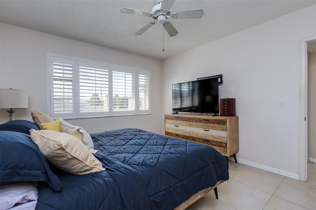 350 South Cypress Road, Unit 522 Pompano Beach, FL 33060 - Photo 25 of 27 a bedroom with a bed and a flat screen tv