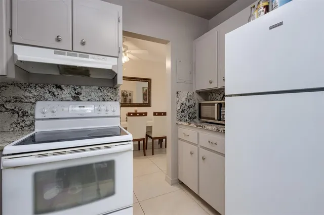 a kitchen with white cabinets and white appliances