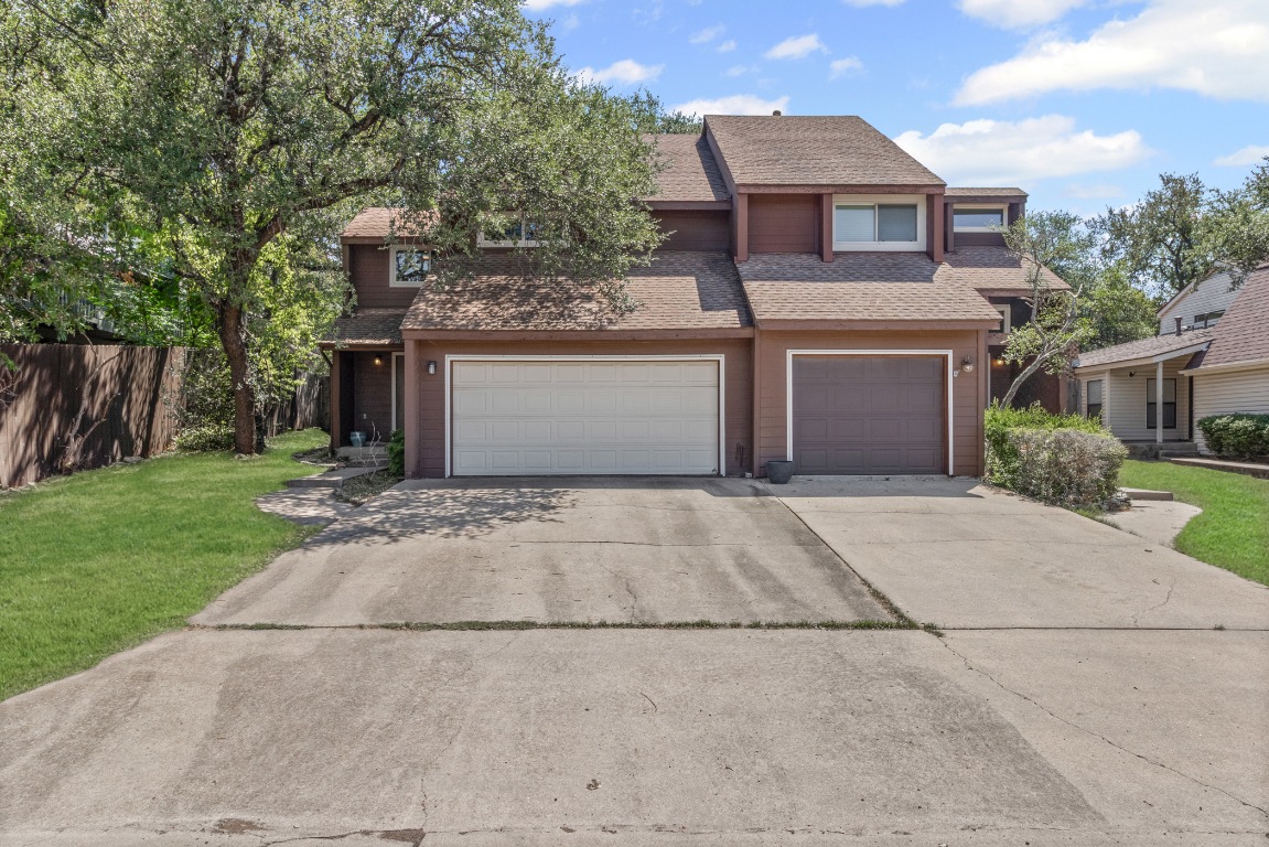 a front view of a house with a yard and a garage