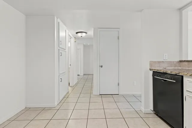 a view of an empty room with closet and mirror