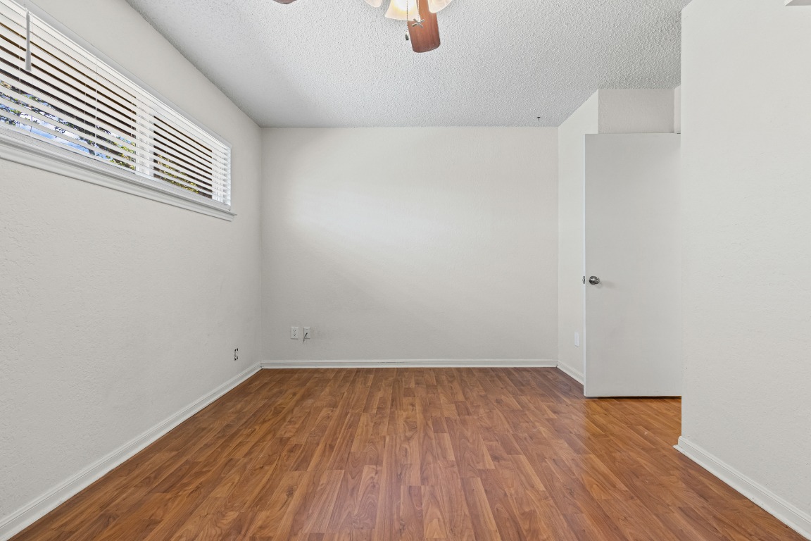 8113 Baywood Drive, Unit A Austin, TX 78759 - Photo 22 of 29 an empty room with wooden floor and windows