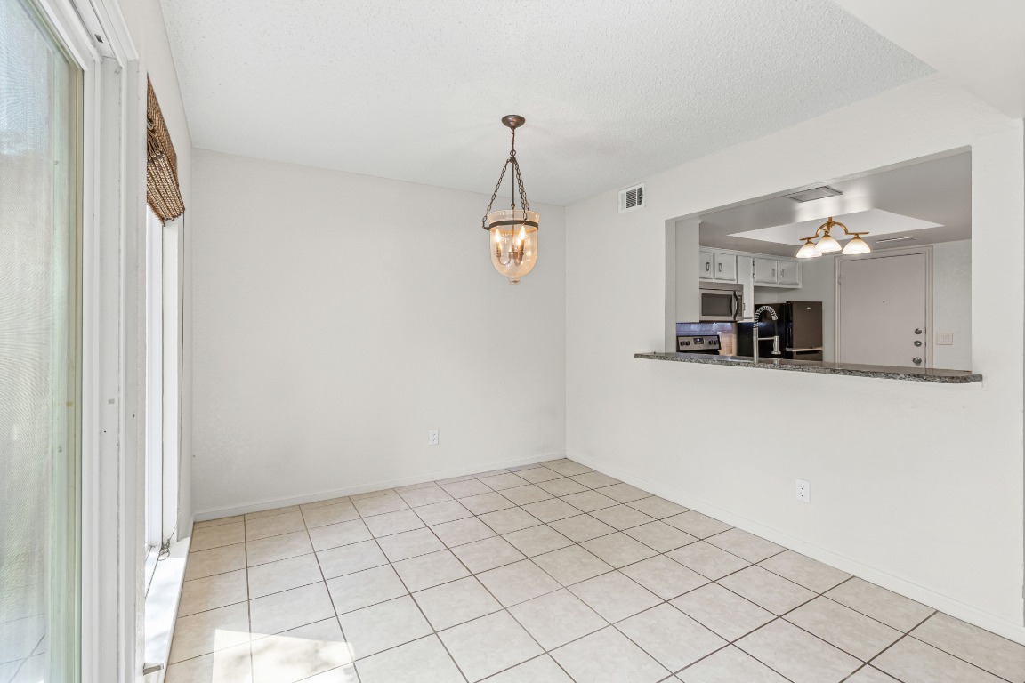 8113 Baywood Drive, Unit A Austin, TX 78759 - Photo 7 of 29 a view of an empty room with window and chandelier fan