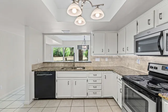 a kitchen with cabinets appliances and a window