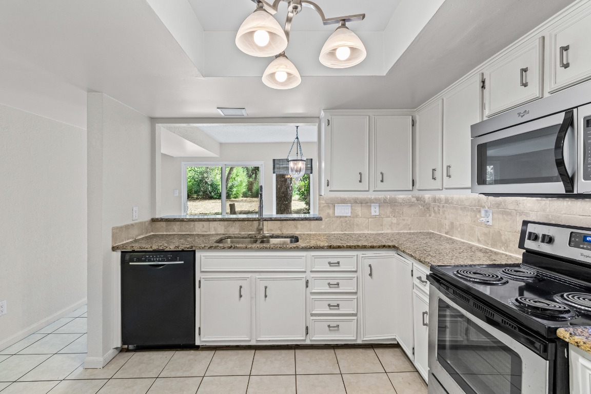 8113 Baywood Drive, Unit A Austin, TX 78759 - Photo 8 of 29 a kitchen with cabinets appliances and a window