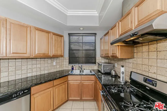 a kitchen with a sink a stove and cabinets