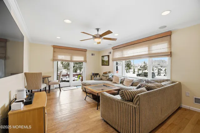 a living room with furniture and a large window with wooden floor