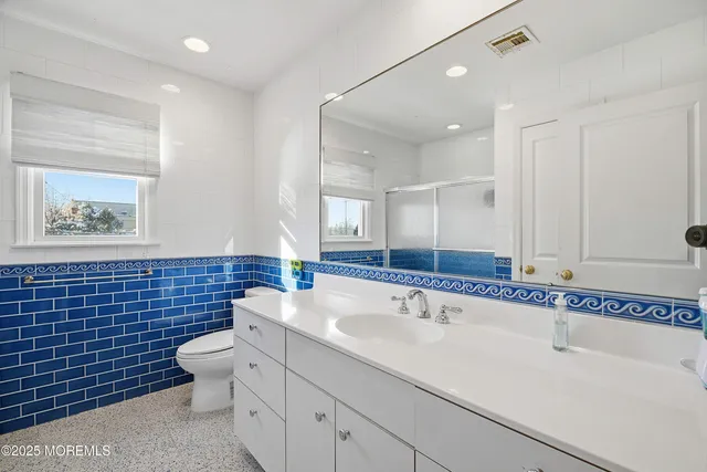 a bathroom with a sink a toilet and mirror