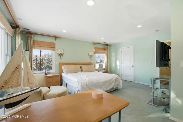 a spacious bedroom with a bed and a flat screen tv