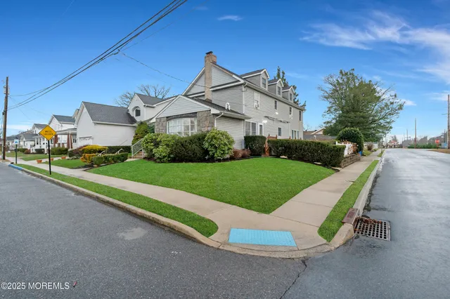 a view of a house with a yard and street