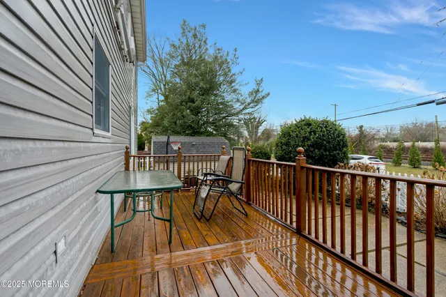 a balcony with wooden floor table and chairs