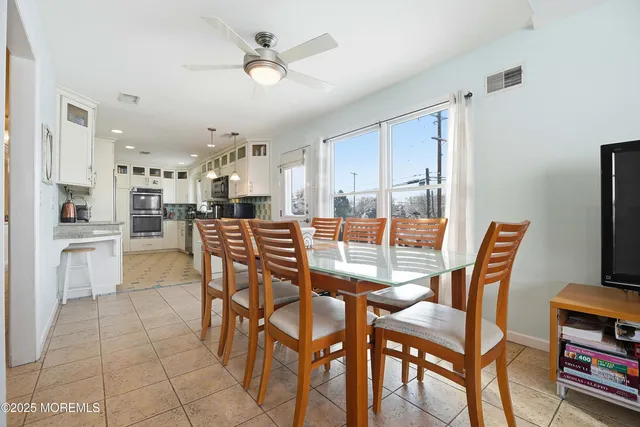 a dining room with furniture and kitchen view