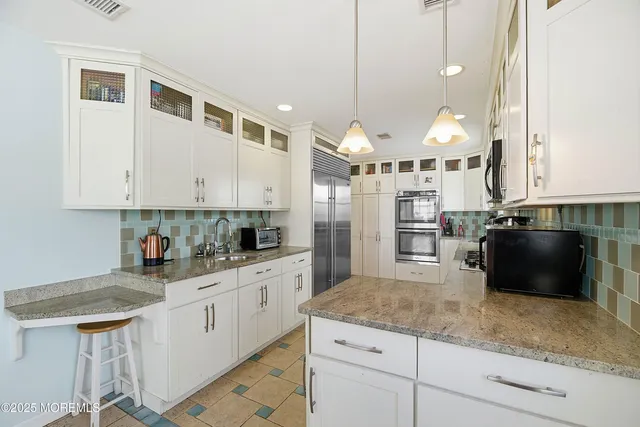 a kitchen with stainless steel appliances granite countertop a stove a sink and a refrigerator