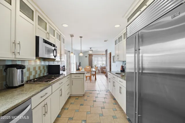 a kitchen with stainless steel appliances a sink a stove and cabinets