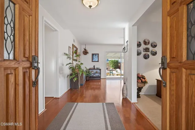 a view of a hallway to a livingroom with furniture and wooden floor