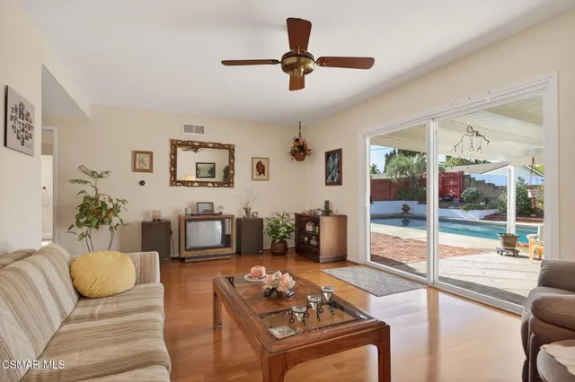 a living room with furniture and a table with potted plants