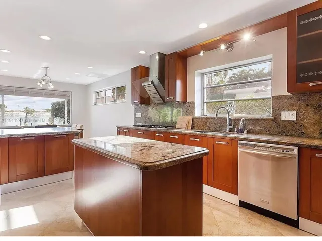 a kitchen with stainless steel appliances granite countertop a sink and a large window