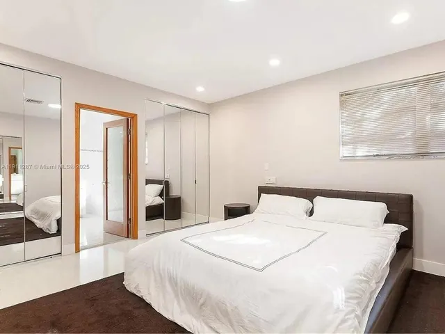 a bedroom with a large bed and a large mirror